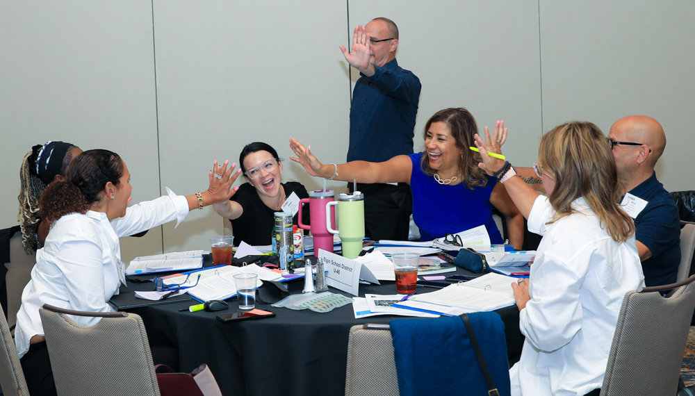 Participant giving each other high five in conference room