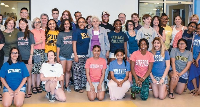 A group of high school seniors wear the t-shirts of their chosen colleges