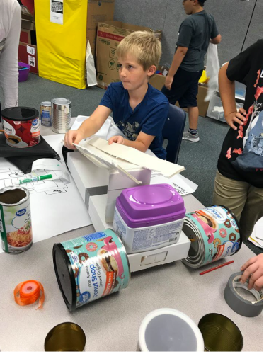 A student creates a robot out of household recycled materials