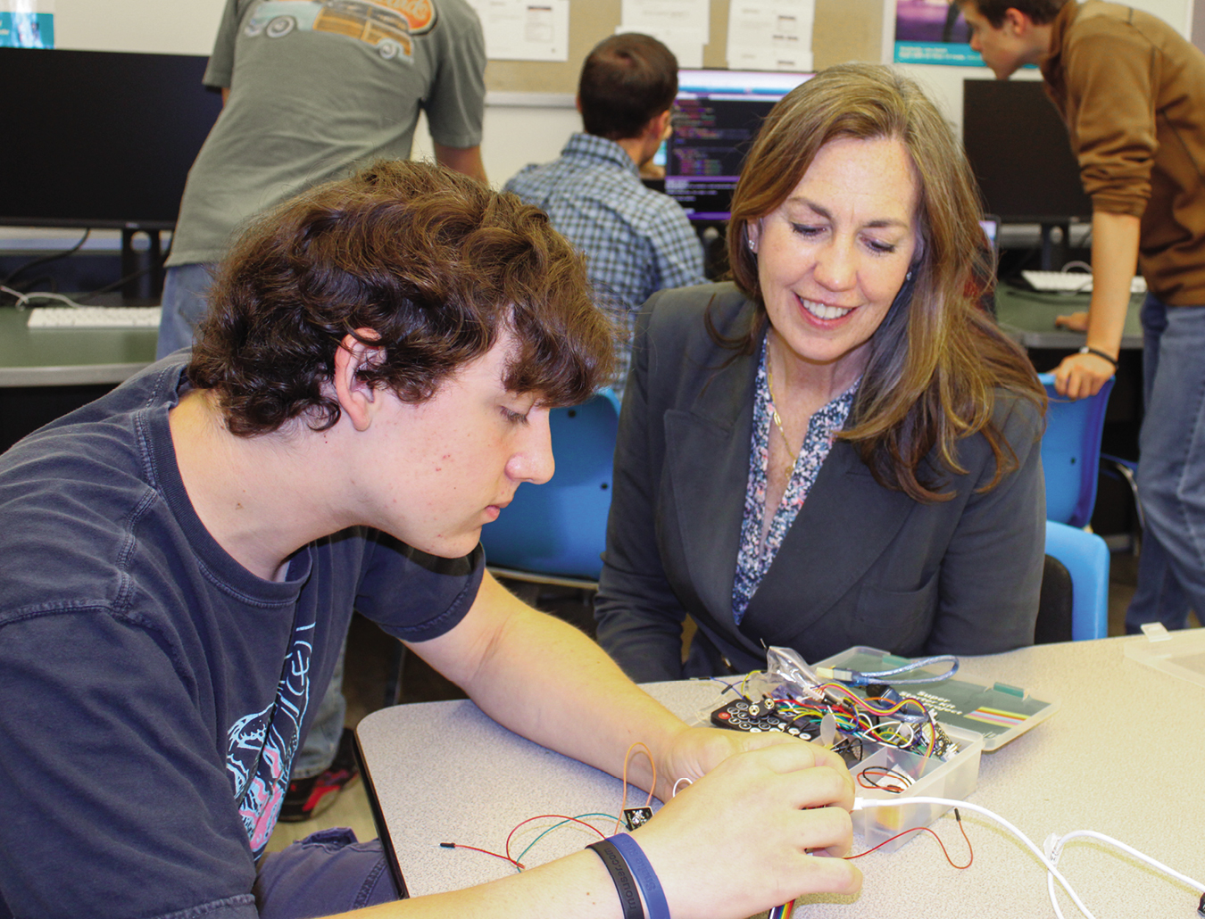 Superintendent Gillian Chapman watches a student wiring something in class