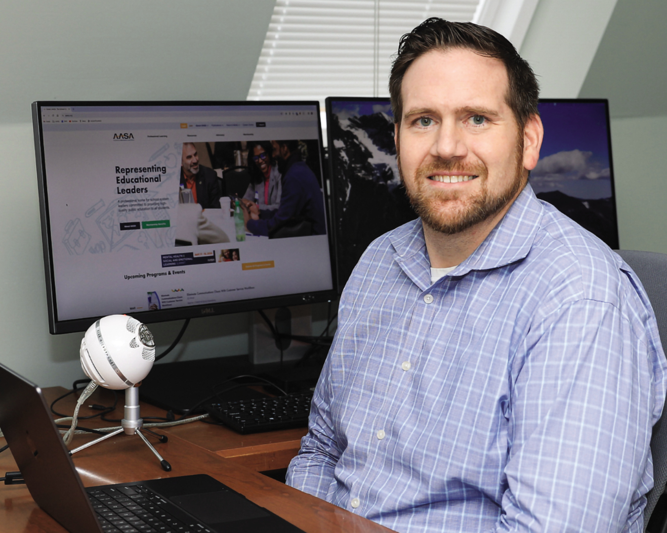 Tony Schlorff sitting at his desk with computer screens behind him