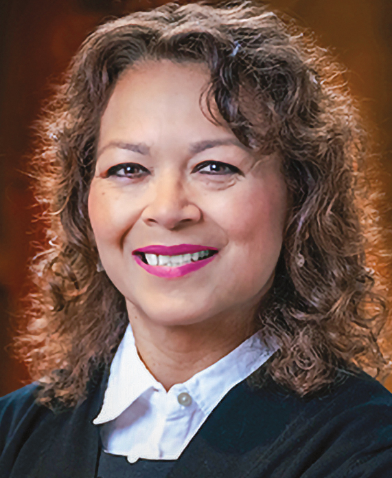 A woman with brown curly hair headshot