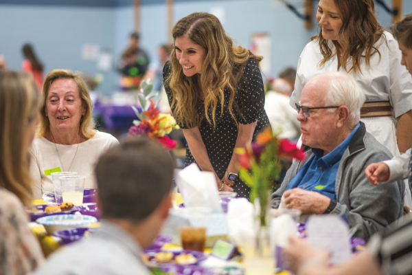 Erin Kane talking at table with students' grandparents