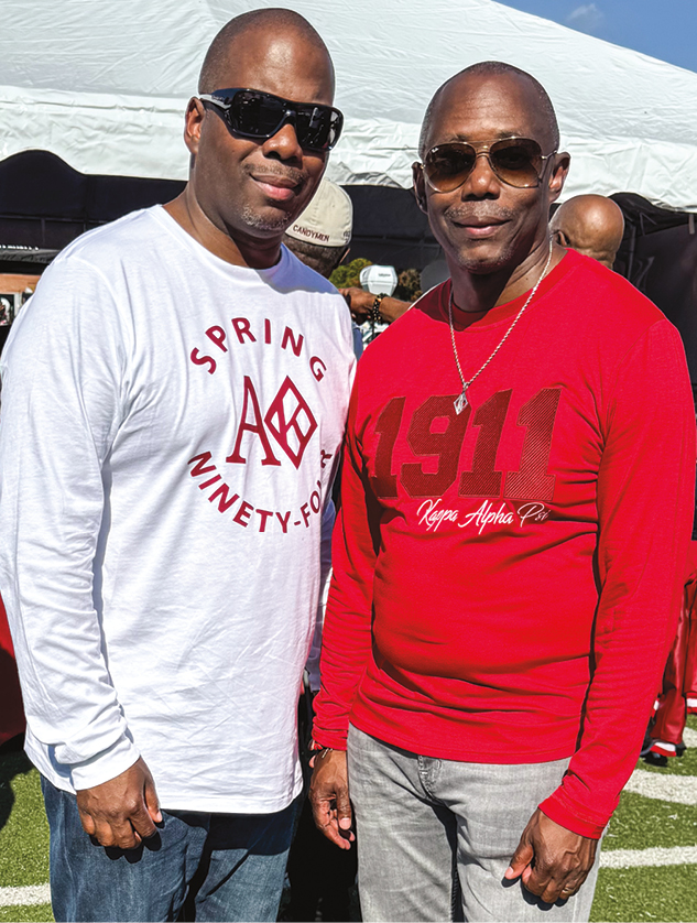 Two brothers standing in casual clothes at a football game