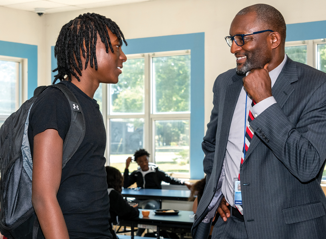 A teenager with his superintendent, who is smiling